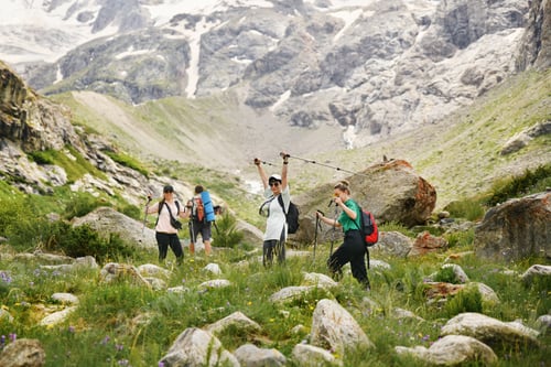 Preview: Women with backpacks and scandinavian sticks climb the mountains
