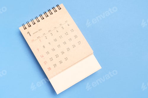 Preview: Brown calendar for 2024 on blue background close-up, planning concept.