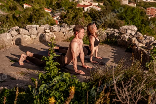 Preview: Couple Practicing Yoga Cobra Pose in Nature