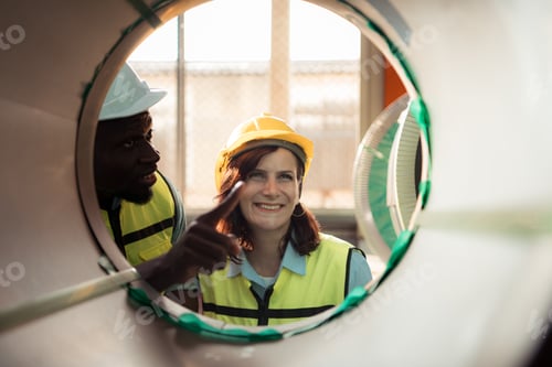Preview: A team of young men and woman working in a warehouse storing rolls of metal sheets.