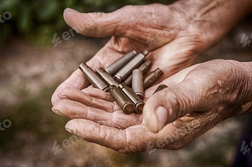 Preview: Shell casings from a gun in the hands of an elderly man. The concept of preserving the world