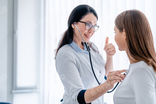 Preview: Female doctor examining young girl in cabinet using stethoscope