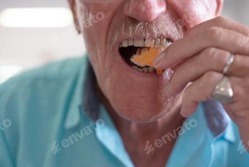 Preview: Close up on caucasian senior man mouth eating bread with spicy oil