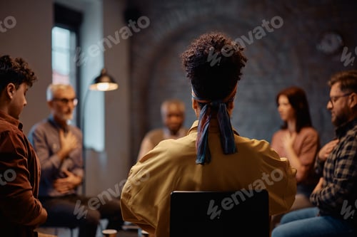 Preview: Rear view of a woman during group therapy at mental health center.