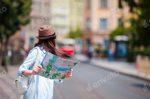Preview: Young woman looking at touristic citymap. Happy girl enjoy vacation holiday in Europe