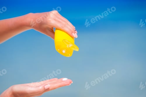 Preview: Closeup suncream bottle background blue ocean and sky
