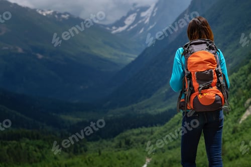 Preview: Backpacker on top of a mountain enjoying valley view