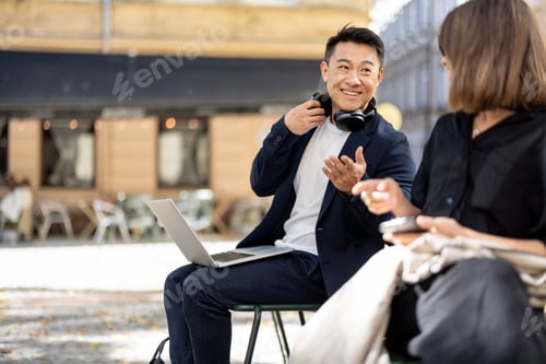 Preview: Asian man and young woman talking on city area