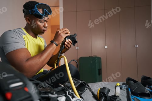Preview: Mixed-race man is adjusting scuba diving equipment