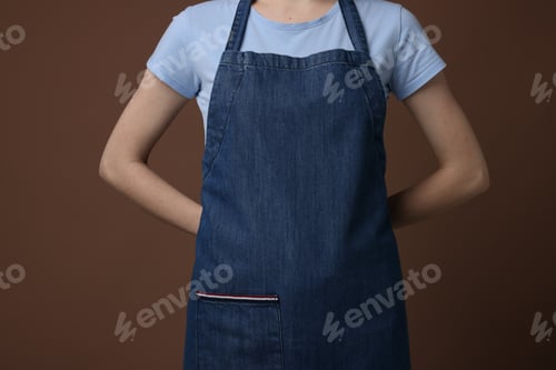 Preview: Woman wearing kitchen apron on brown background, closeup. Mockup for design