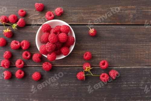 Preview: Red fresh raspberries on brown rustic wood background