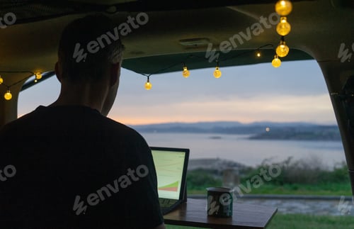 Preview: Man working remotely from his camper van on the sea coast