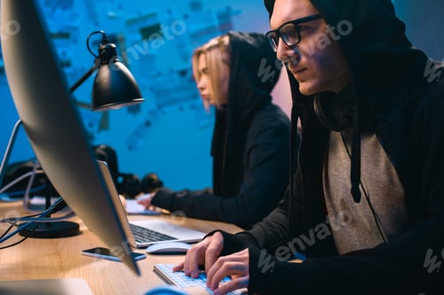 Preview: couple of hackers working with computers to develop new malware
