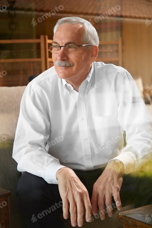 Preview: Senior man at home, sitting in chair, looking away