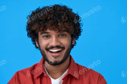 Preview: Happy young indian guy laughing isolated on blue background. Headshot portrait