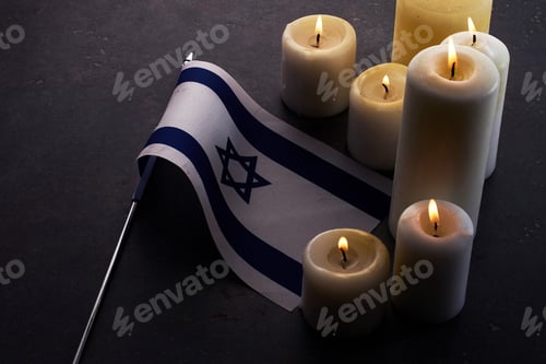 Preview: Burning candles and flag of Israel on dark background. Holocaust remembrance day