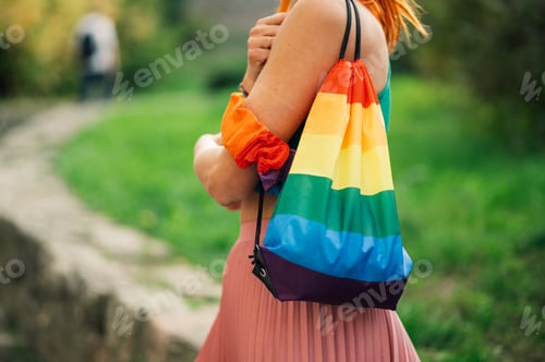 Preview: Woman wearing rainbow backpack showing support for lgbtq plus community in park