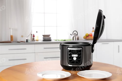 Preview: Modern multi cooker and empty plates on table in kitchen