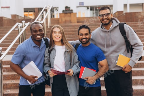 Visualização: Grupo diversificado de estudantes universitários felizes posando juntos nos degraus do campus segurando cadernos
