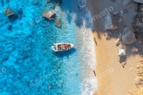 Preview: Aerial view of boat, sandy beach, blue sea with waves at sunset