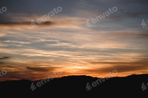 Vorschau: Eine wunderschöne Aufnahme der Silhouette eines Hügels mit goldenem Sonnenuntergang im Hintergrund