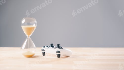 Preview: Gaming joystick and hourglass display play time flowing, a clear sand timer concept for video game
