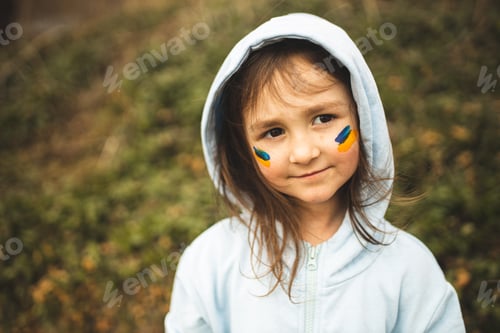 Preview: Girl with a Ukrainian flag on her face. A child from Ukraine. Russia's war against Ukraine. Ukraine.