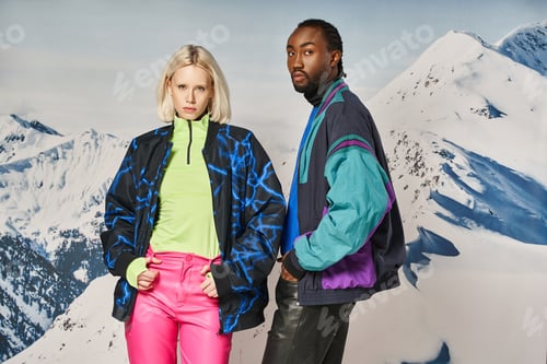Preview: stylish diverse couple in bright warm attire posing together and looking at camera, winter concept