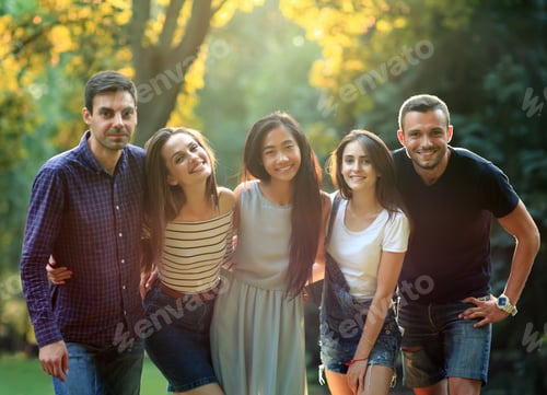 Preview: Five young people friends looking at camera in sunny park