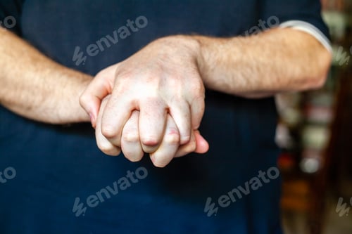 Preview: Detailed closeup of a man's clasped hands expressing emotion