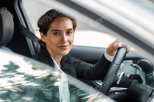 Preview: Young female in formal wear driving a car