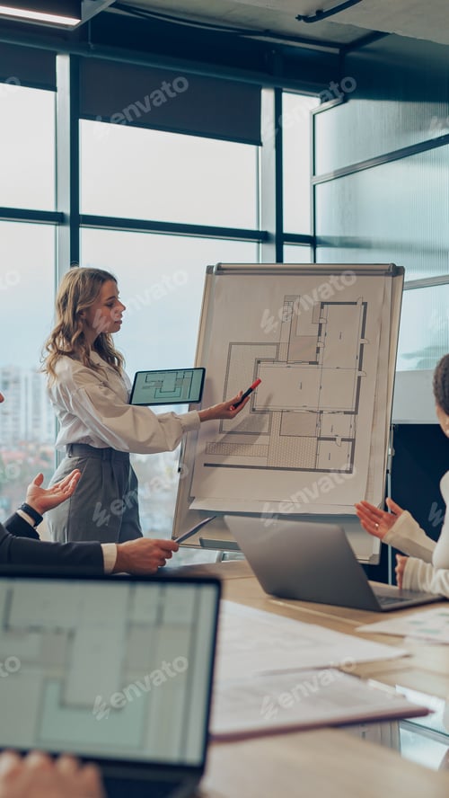 Preview: Confident young businesswoman giving a presentation during a meeting with her colleagues