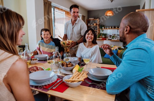 Preview: Family and friends reunion at home. Diverse family gathering enjoying dinner at home