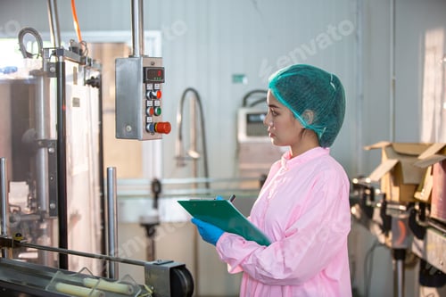 Preview: worker controlling the work of machine in production line at beverage industry.