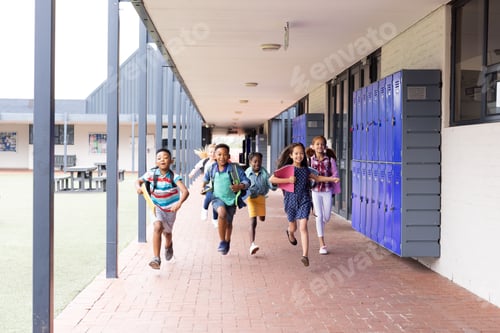 Preview: Diverse, happy children with schoolbags running in elementary school corridor, copy space