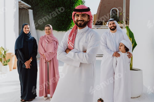 Preview: Emirati family standing together smiling in traditional attire
