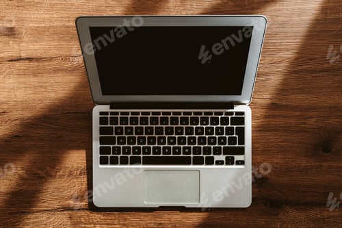 Preview: Top view of laptop computer on office desk with blank black mockup screen and copy space