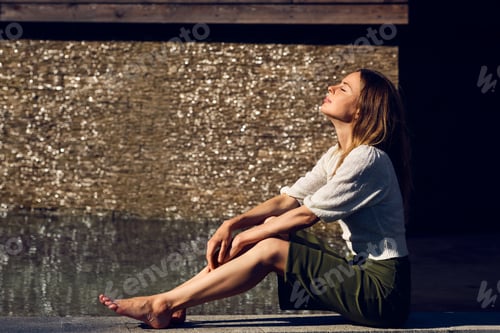 Preview: Girl relaxing under the sun near the water in sultry hot day