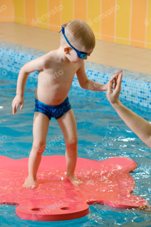 Preview: Toddler child trained to dive in indoor swimming pool