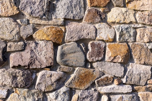 Preview: Background from a wall with stones in sunlight