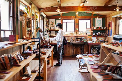 Preview: Japanese woman browsing merchandise in a leather shop.