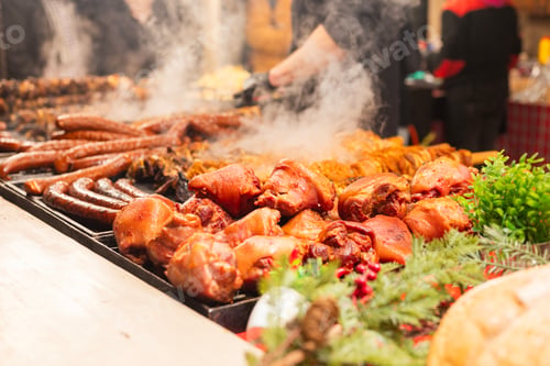 Preview: vendor fries meat and sausage on the grill in the city center at the Christmas market