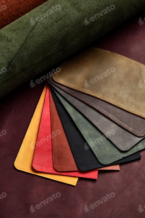 Preview: Artificial leather samples on a cow leather background. Top view.