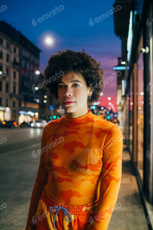 Preview: Young black woman curly hair stylish fashionable posing outdoor looking camera cool attitude