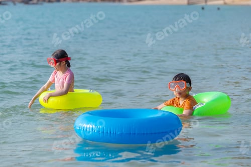 Preview: Children playing colored inflatable rings joyful beach during playful.