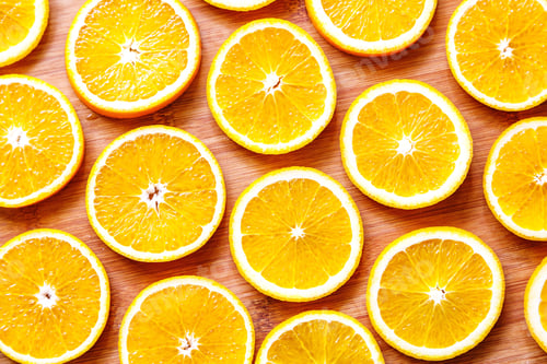 Preview: Flat lay of sliced fresh oranges on wooden cutting board. Bright background with healthy eating