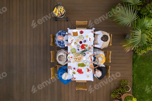 Preview: Top view of terrace with table full of food and seniors sitting at it