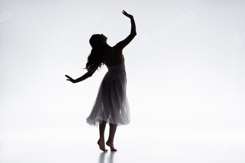 Preview: graceful, elegant ballerina in white dress dancing on grey background