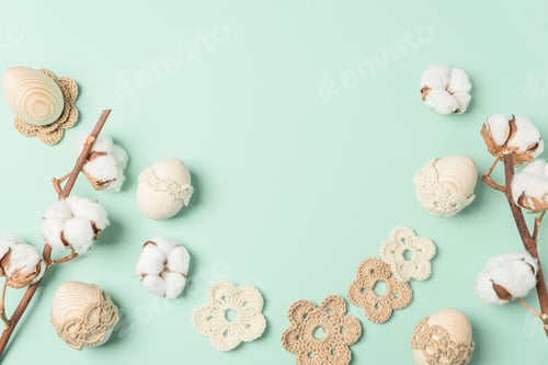 Preview: Craft eggs, knitted and cotton flowers on soft green background. Top view. Copy space