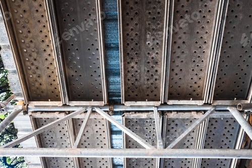 Preview: Metallic scaffolding placed on the street during the repairs of a building, seen from below.
